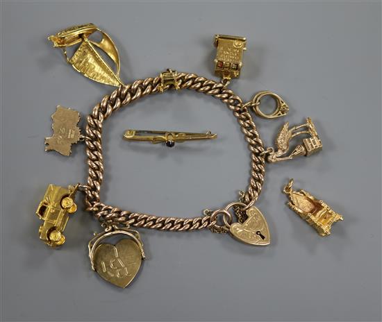 A 9ct gold charm bracelet hung with eight assorted charms, a tiepin and a coronation chair charm, bracelet gross 57.9 grams.